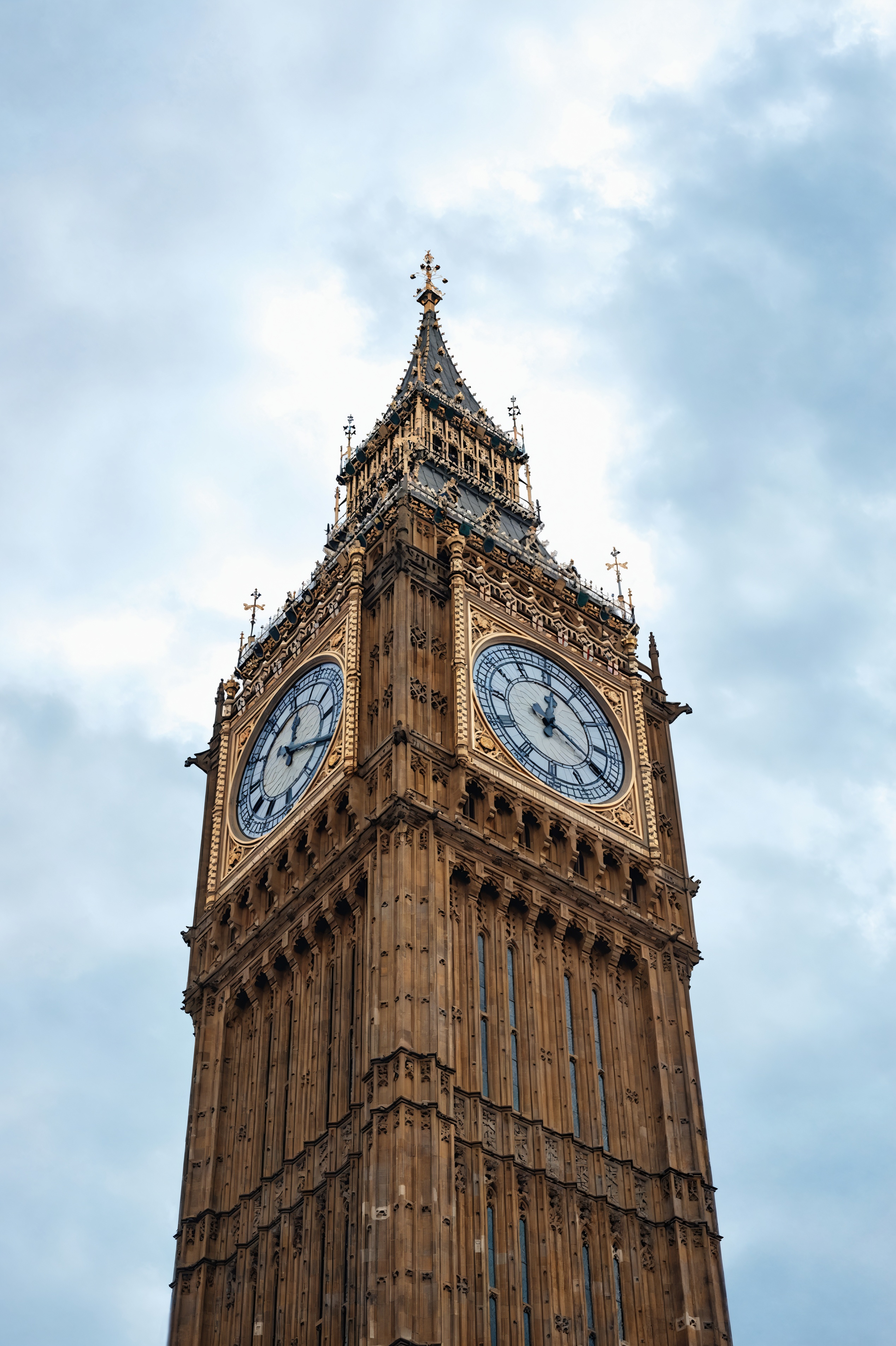 Big Ben clock tower showing ornate Gothic architecture with illuminated clock faces.