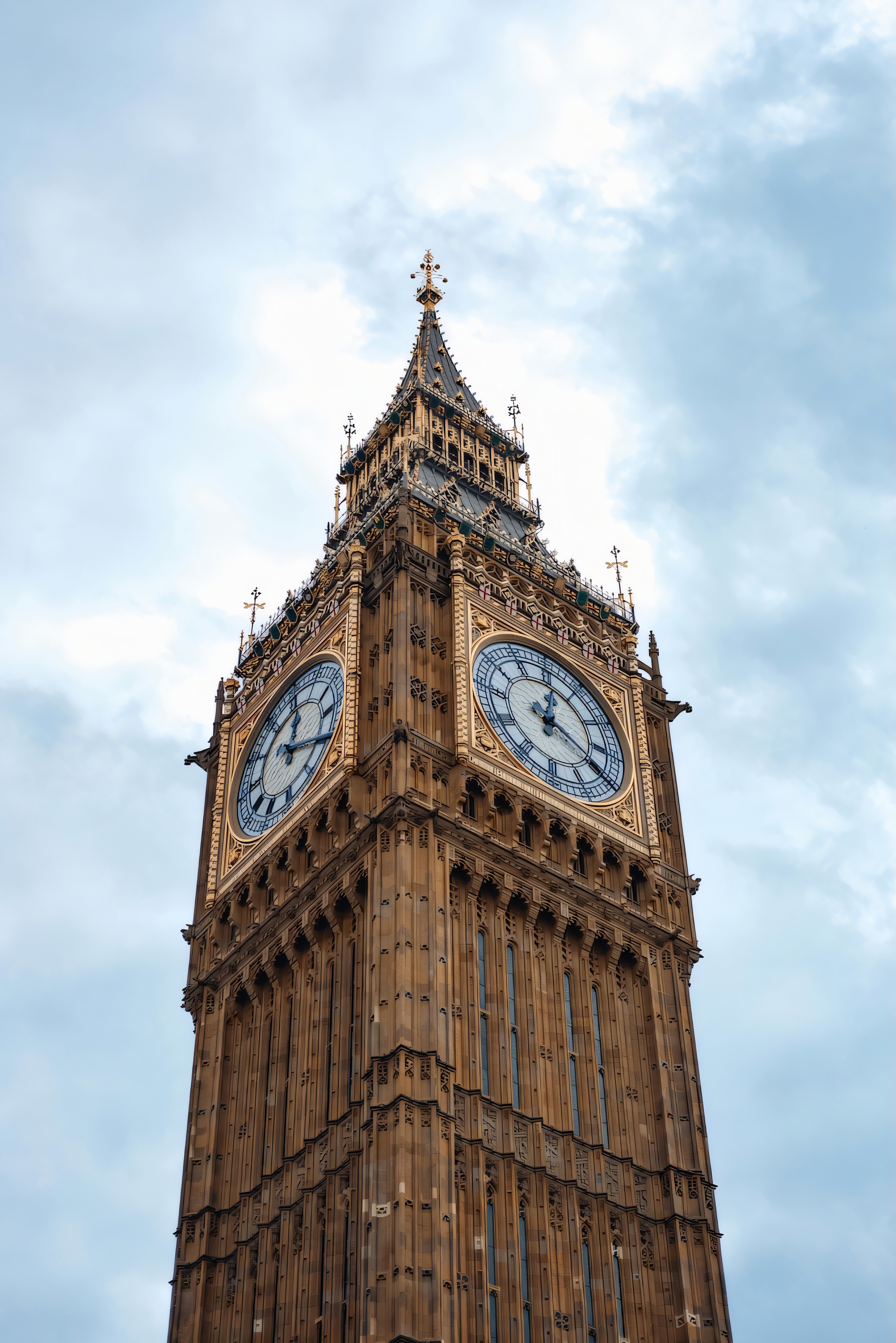Big Ben clock tower showing ornate Gothic architecture with illuminated clock faces.