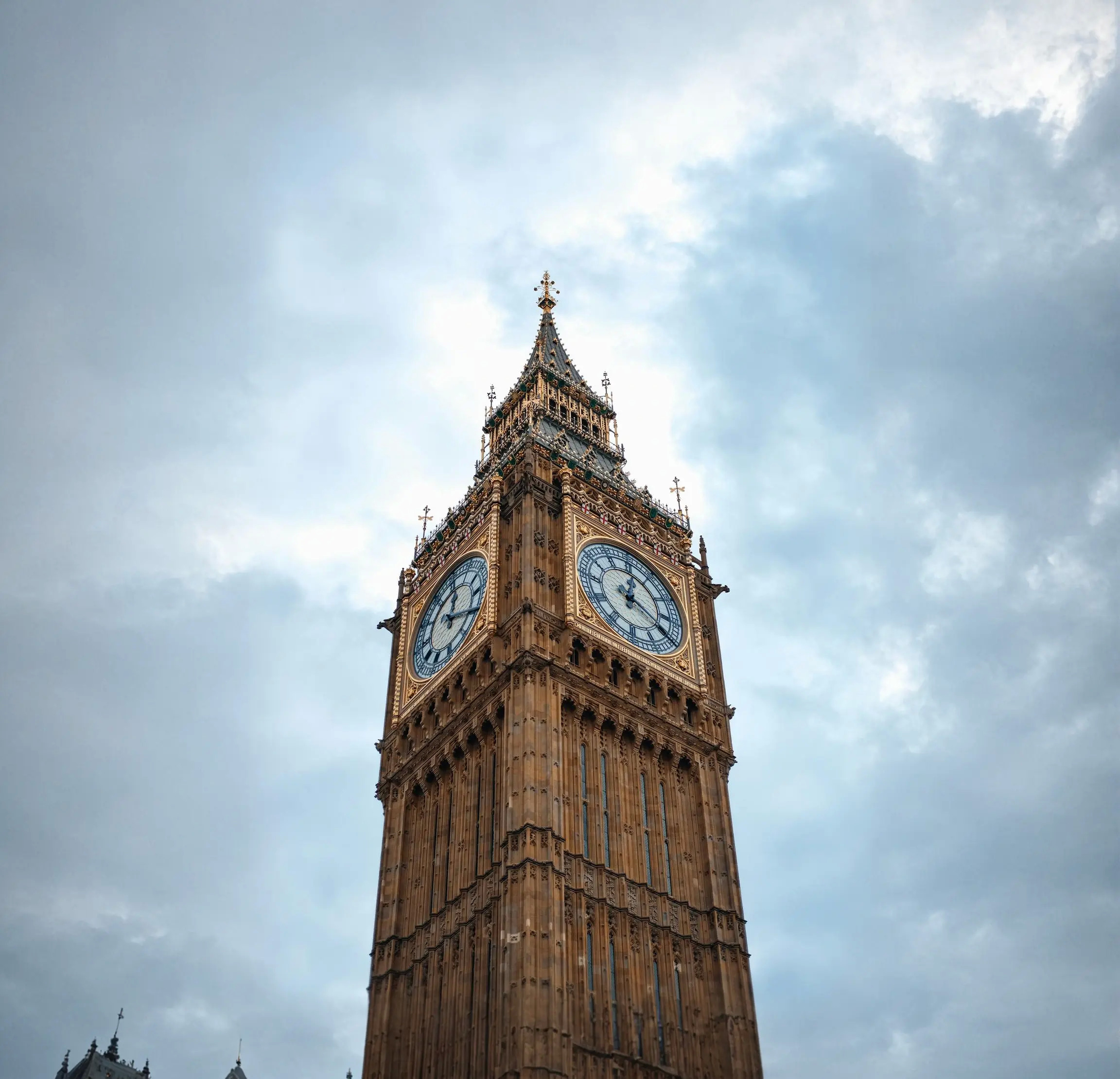 Big Ben clock tower with ornate Gothic architecture against cloudy sky.